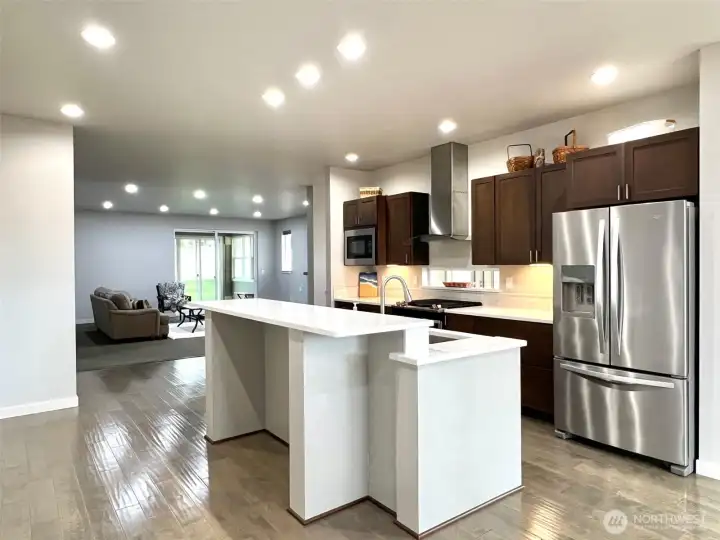 A spacious island serves as the centerpiece, offering ample prep space and casual seating for gatherings.