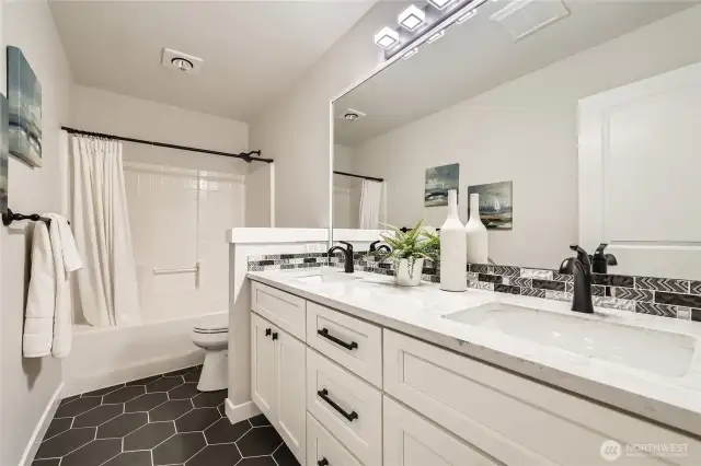 Full Guest Bath with quartz dual sinks and custom floor tile.