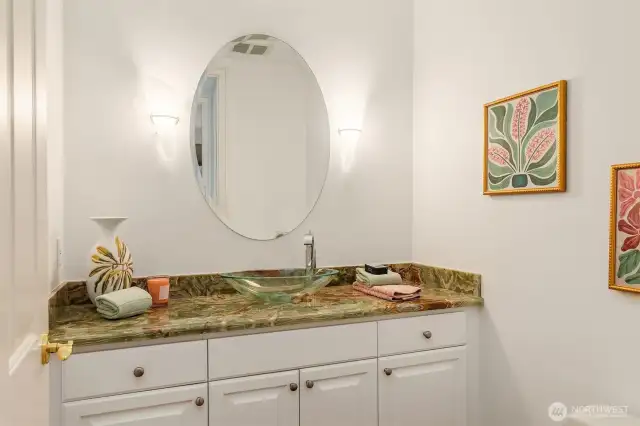 The powder room with custom lighting, beautiful granite counters and glass bowl.