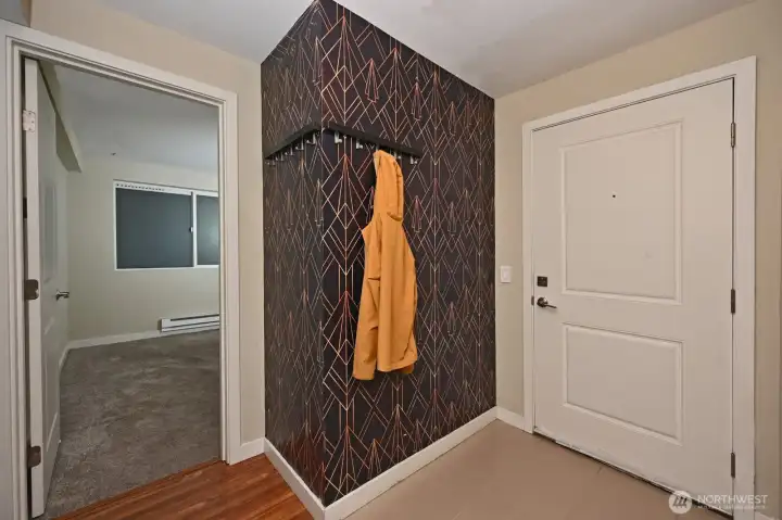 The foyer for this ground level condo includes a wall mounted coat rack.