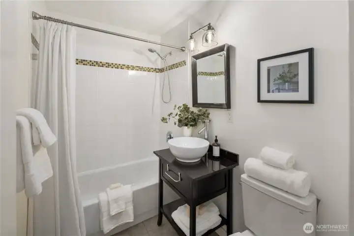 Bathroom is off hallway between kitchen and bedroom