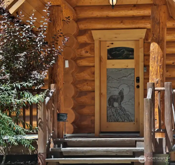 Custom wood entry with carved wildlife detail sets the tone for this authentic mountain lodge.