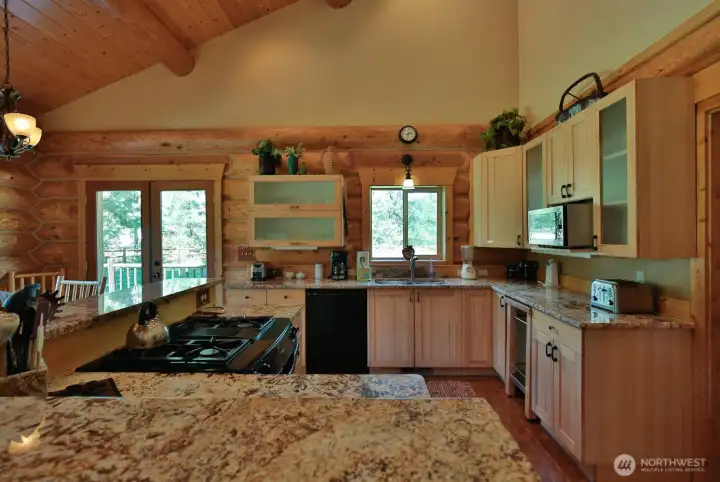 Well-appointed kitchen with granite countertops and ample prep space, seamlessly connected to dining and outdoor living.