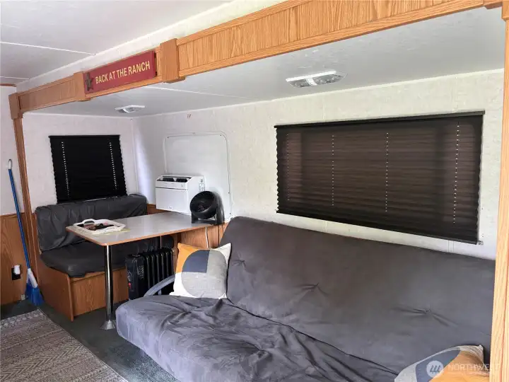 Living area with pull down couch and bed dinette.