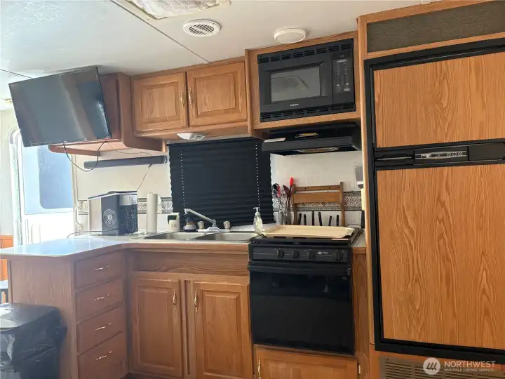 Nice kitchen area with large fridge, oven and microwave.