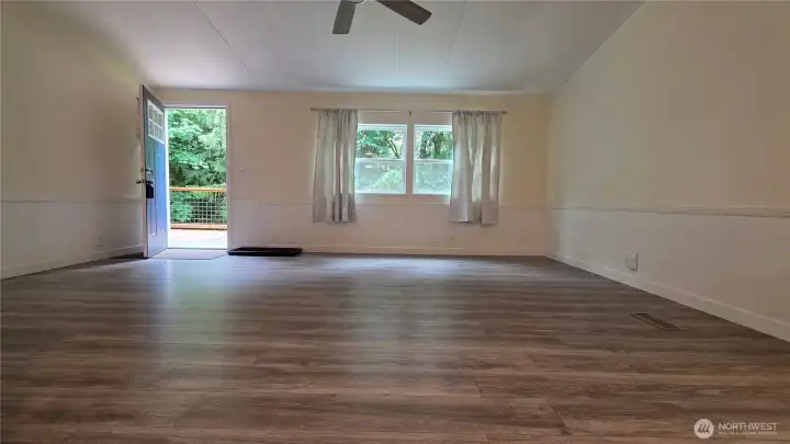 Living room has nice natural light, showing of the beautiful, nearly new laminate flooring!