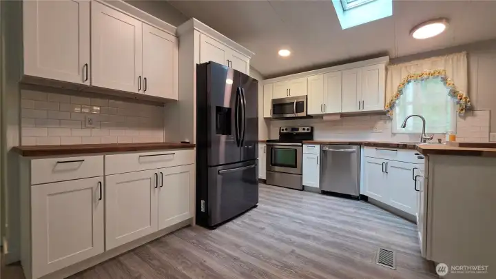Nice black stainless refrigerator and SS range/oven microwave & dishwasher make kitchen creations fun!