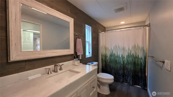 Spacious primary bathroom has entry to primary bedroom and the laundry room for convenience