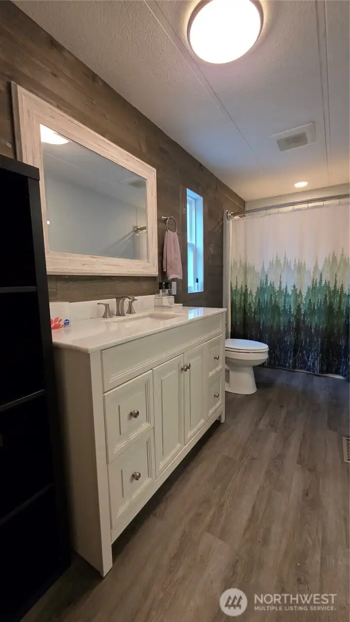 Additional cabinet next to the vanity adds great storage in the primary bathroom.