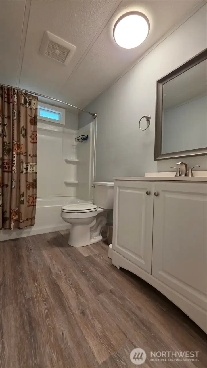 Main bathroom has transom window above shower for natural lighting