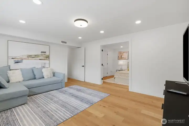 The lower level  spacious rec room, offering flexibility for guests, multi-generational living, or a dedicated work-from-home setup.