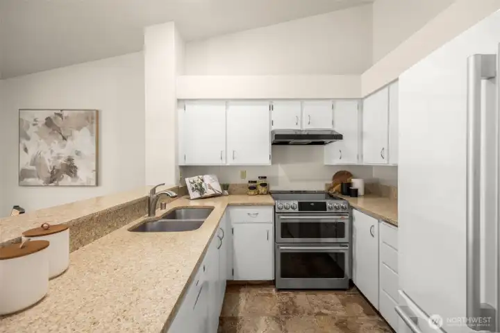 Quartz countertops, a breakfast bar, and a double oven make this kitchen equally suited for everyday routines and weekend entertaining.