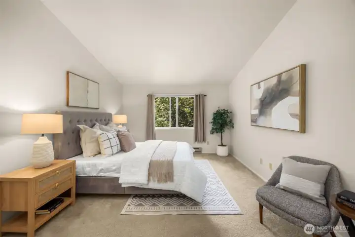 Vaulted ceilings and peaceful treetop views give the primary suite a sense of privacy and retreat.