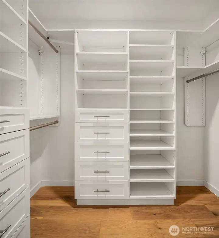 Spacious primary walk-in closet with custom built-ins. Spacious primary walk-in closet with custom built-ins.