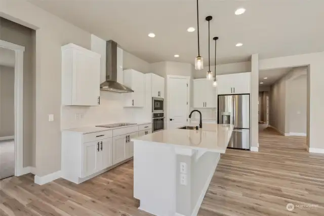 Gourmet island kitchen with range hood, smooth top cook top and French door fridge