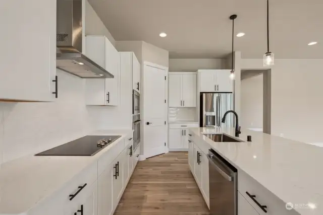 View of kitchen from the dining area showing the smooth top cook top, range hood and dishwasher