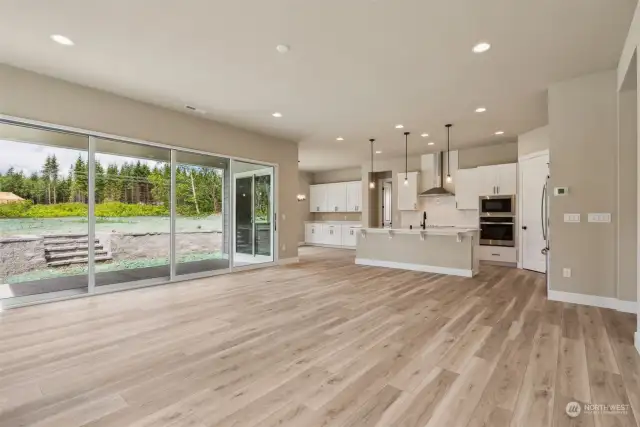 Great room view of kitchen and multi panel slider leading to the spacious covered patio