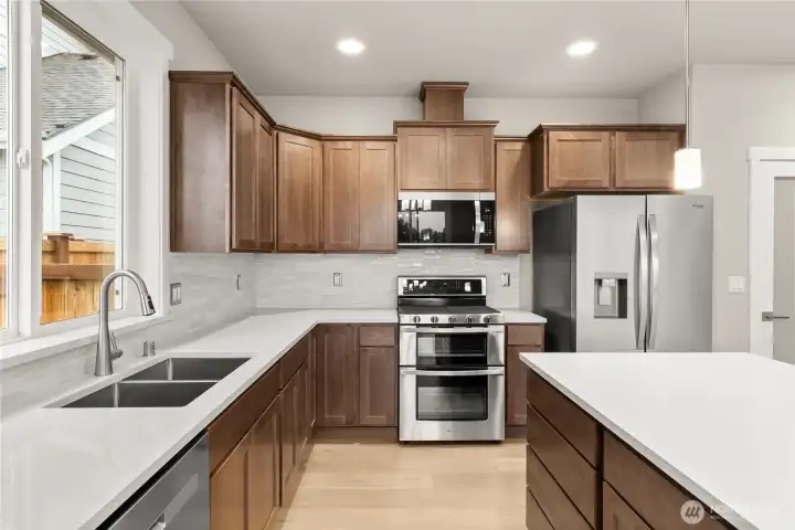 Sable-stained maple cabinets throughout home. Double oven is standard as well as microwave and dishwasher. This home also includes a refrigerator!