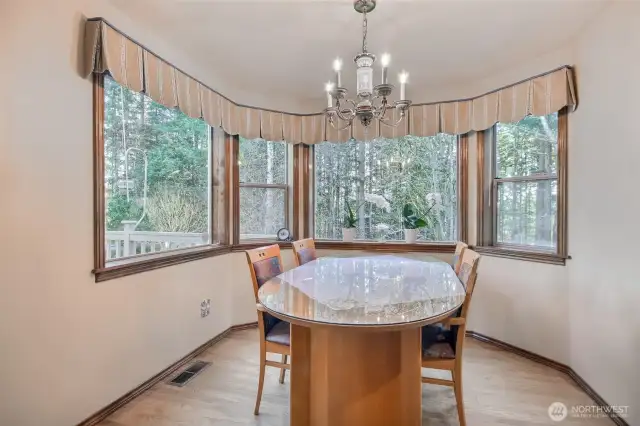 Nook off the kitchen with wall of windows to look out greenbelt view and manicured backyard