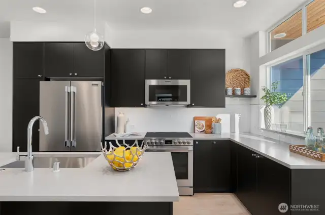 Crisp lines, under-cabinet lighting, and stainless steel appliances bring sophistication and function together in this culinary hub.
