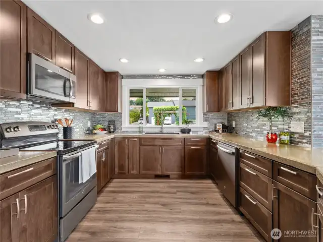 A striking portrait window takes center stage in this beautiful kitchen, framing the view as you cook.
