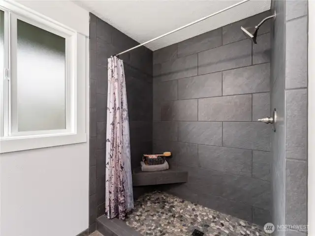 Primary bathroom showcases impeccable updated tile work and refined finishes.