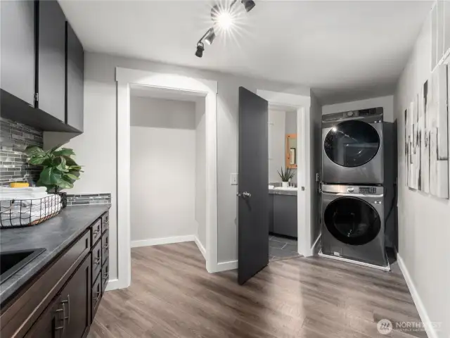 Versatile walk-through laundry room featuring a bathroom, sink area, and ample storage.
