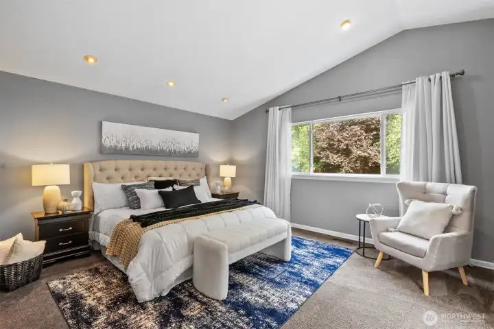 Primary suite - private with vaulted ceilings, leading into  ensuite bathroom.