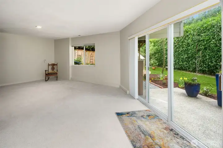 lower level features a versatile rec room with sliding doors that open to a side patio