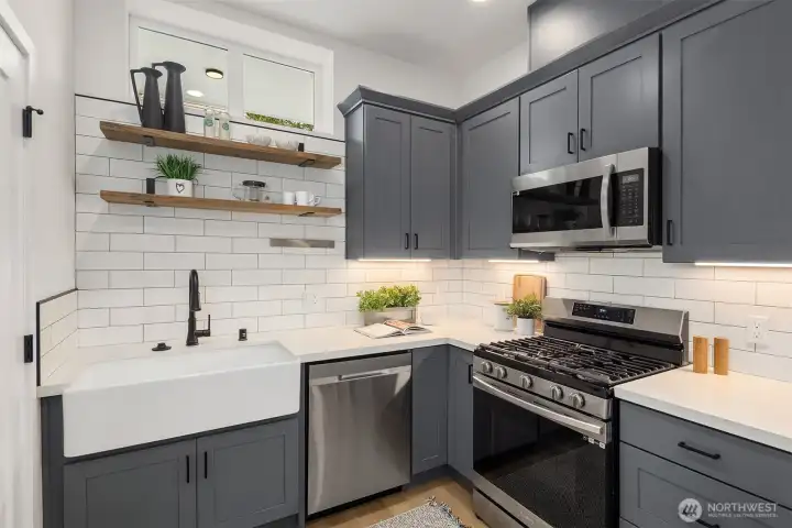 Well-appointed kitchen with large farmhouse sink, stainless appliances and an efficient layout.
