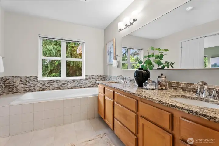 The primary suite has a large soaking tub, double vanity and a toilet room with standing shower.