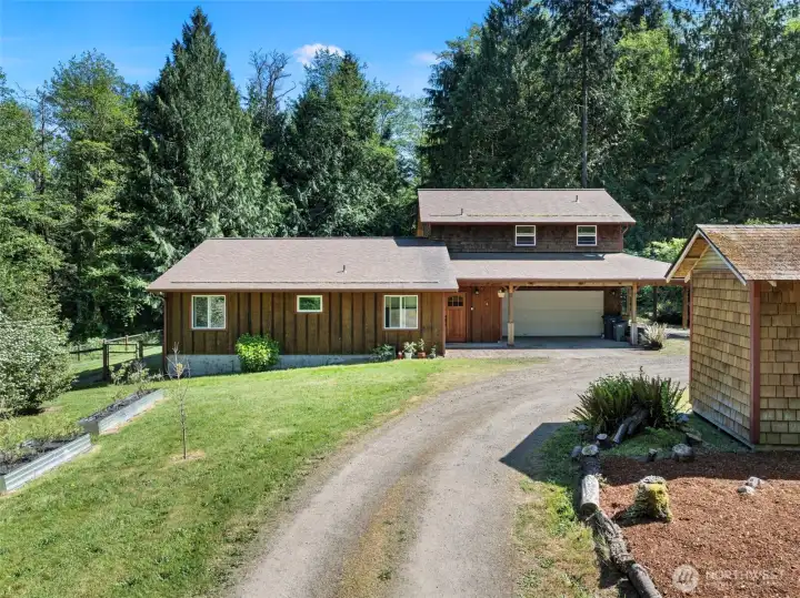 Main home as you enter on driveway with the well house on the right.