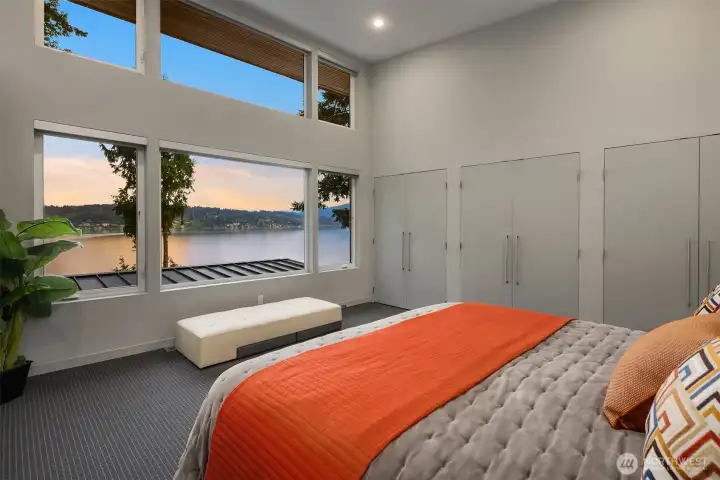 Primary bedroom with mesmerizing lake views, custom closets and vaulted ceilings.