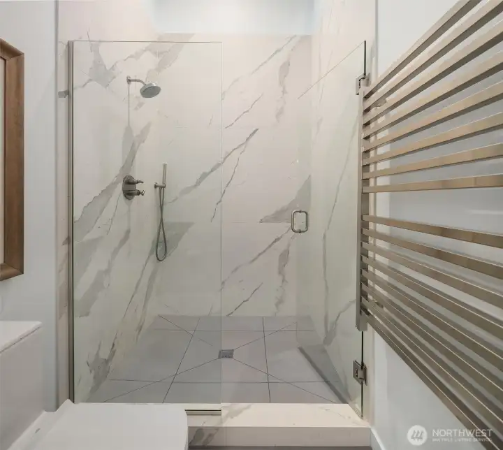 Primary luxurious bath complete with towel warmer and elegant design.