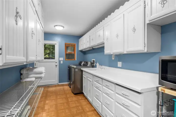 Generous utility room leads to the backyard