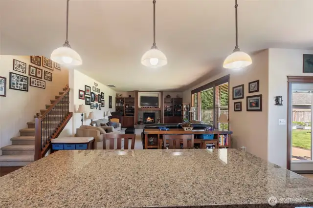 View of main room from kitchen with stairs on the left