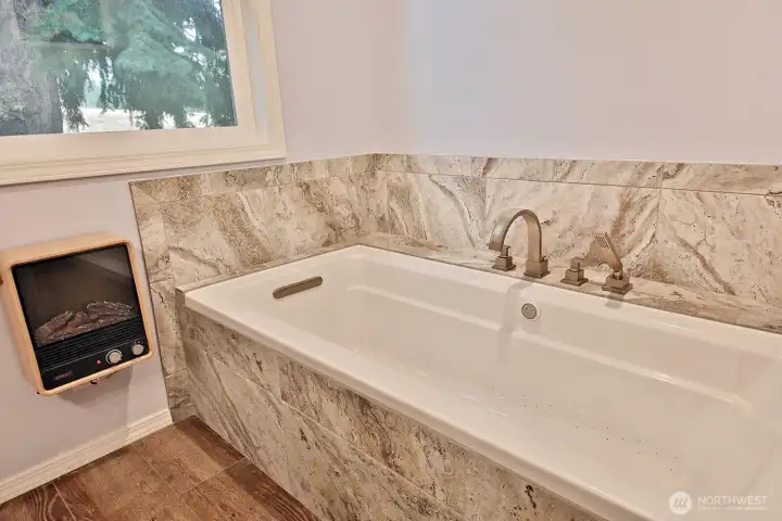 Deep soaking tub, ceramic tile floors and a sweet electric fireplace heater. The window in this bathroom perfectly frames the beautiful Fir tree that stands tall in your backyard.