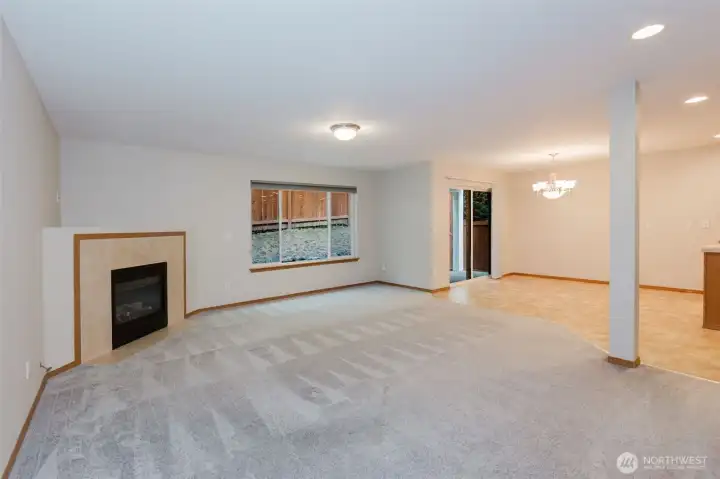 Spacious living room with cozy fireplace and large window.