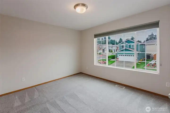Additional bedroom with carpet and natural light.