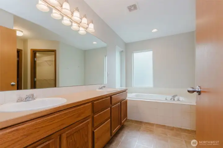 Primary en-suite with soaking tub and dual sinks.