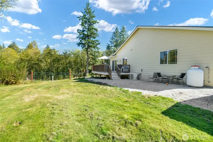 Fenced yard on north side of home with deck