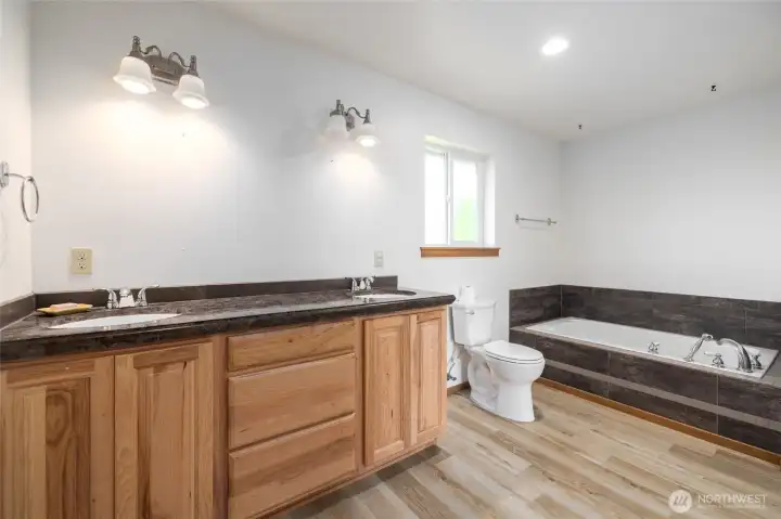 The primary bathroom (mirror has been added now.) with double sinks, a tub and shower.