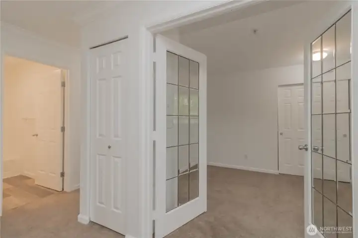 Den/office accessed through elegant French glass doors, featuring convenient closet storage.