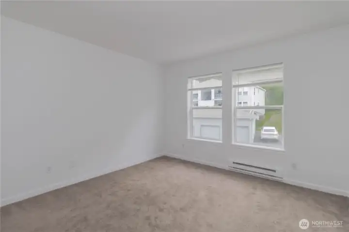Additional view of the primary suite showcasing abundant natural light from large windows.