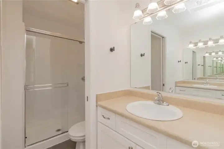 Primary bathroom featuring dual sink vanities and a separate shower area.