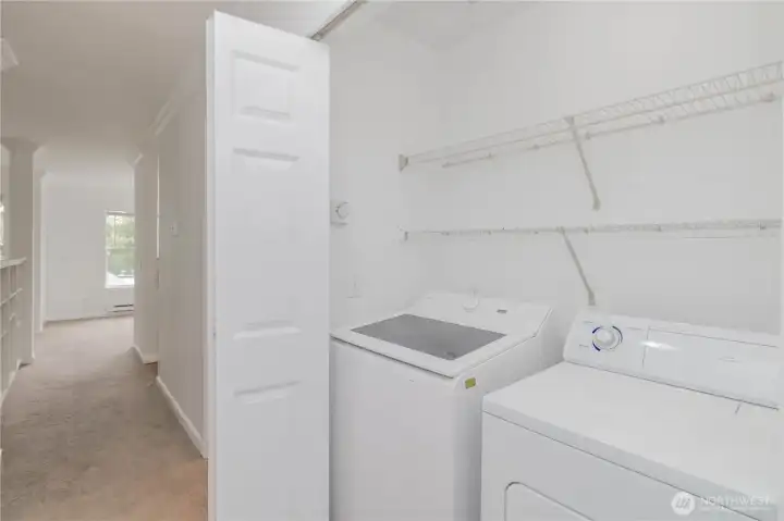 Convenient in-unit washer and dryer with additional shelving for storage.