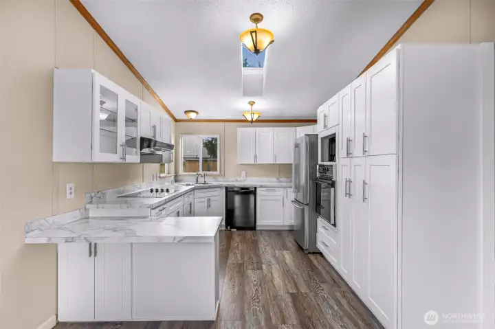 The recently updated kitchen invites you with bright white cabinets and sklights