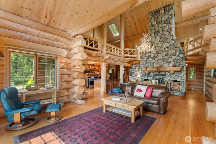Vaulted lodge-style great room centered around the dramatic hand-stacked river rock fireplace