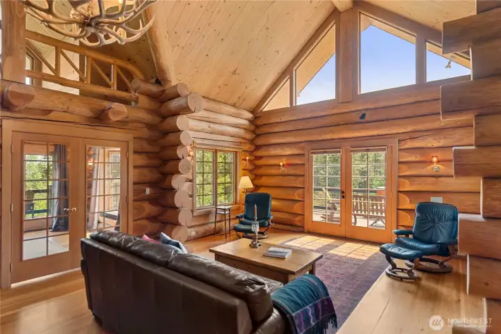 Walls of windows and French doors open seamlessly to the expansive view deck, filling the great room with natural light and creating an effortless connection to the surrounding mountain landscape.