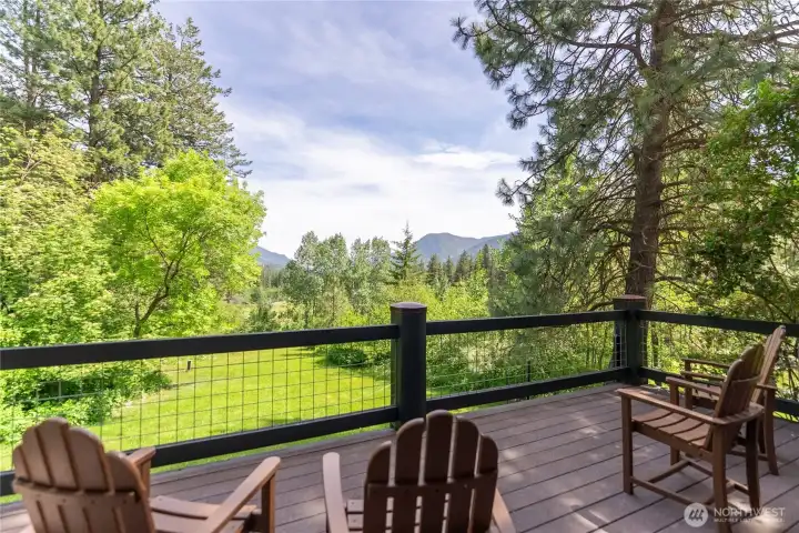 Private primary suite deck with peaceful mountain and meadow views, an ideal setting for morning coffee, stunning sunrises, and the soothing sounds of the nearby Thiese Creek waterfall flowing through the property.